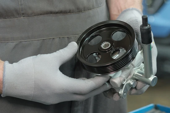 Atelier industriel avec pièces automobiles blanches empilées sur palettes